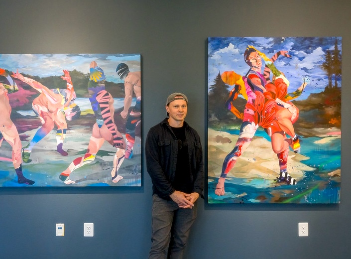 Mark Engle stands in front of paintings in Vargas Gallery.