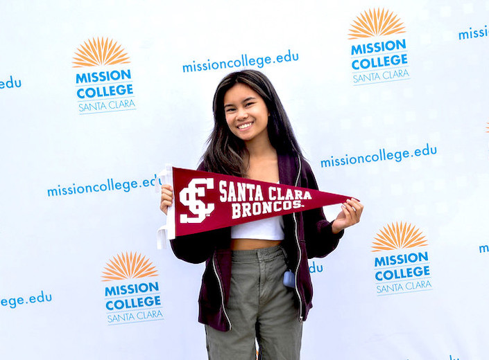 Asian-American female college student holds Santa Clara University pendant.