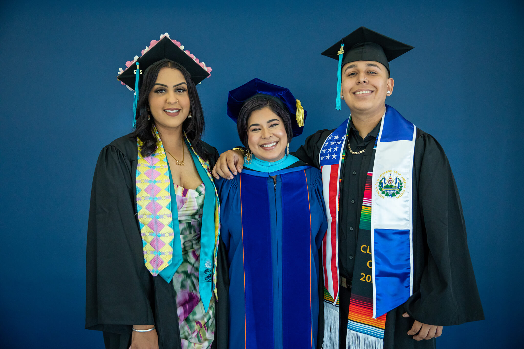 Seher Awan posing with two graduates in their commencement robes