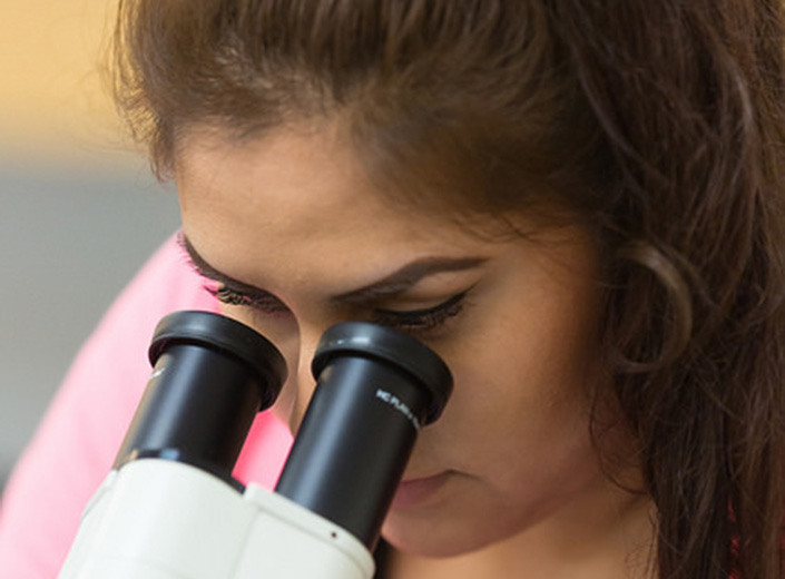 student looking in microscope