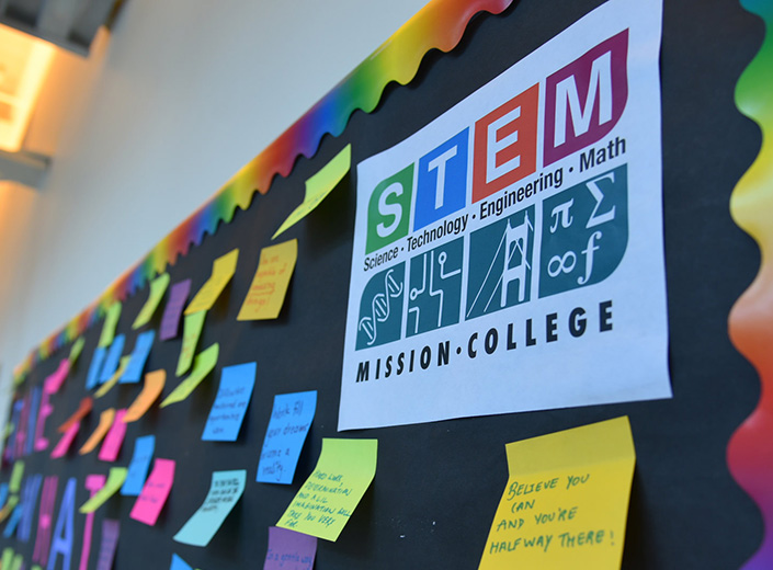 A colorful flyer is posted on a bulletin board that reads "STEM" in a college classroom.