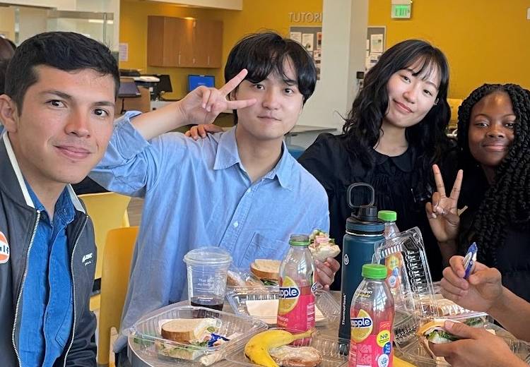 IIS students eat lunch together at a table.